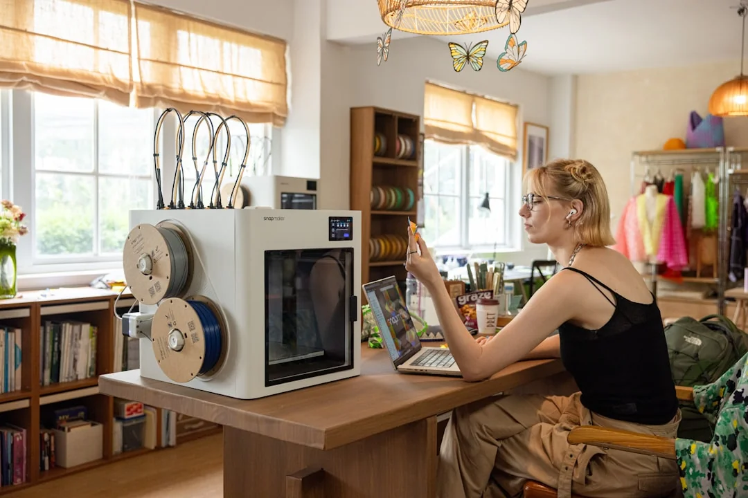 A person in light clothing browses a creative portfolio on a laptop, showcasing artistic designs.